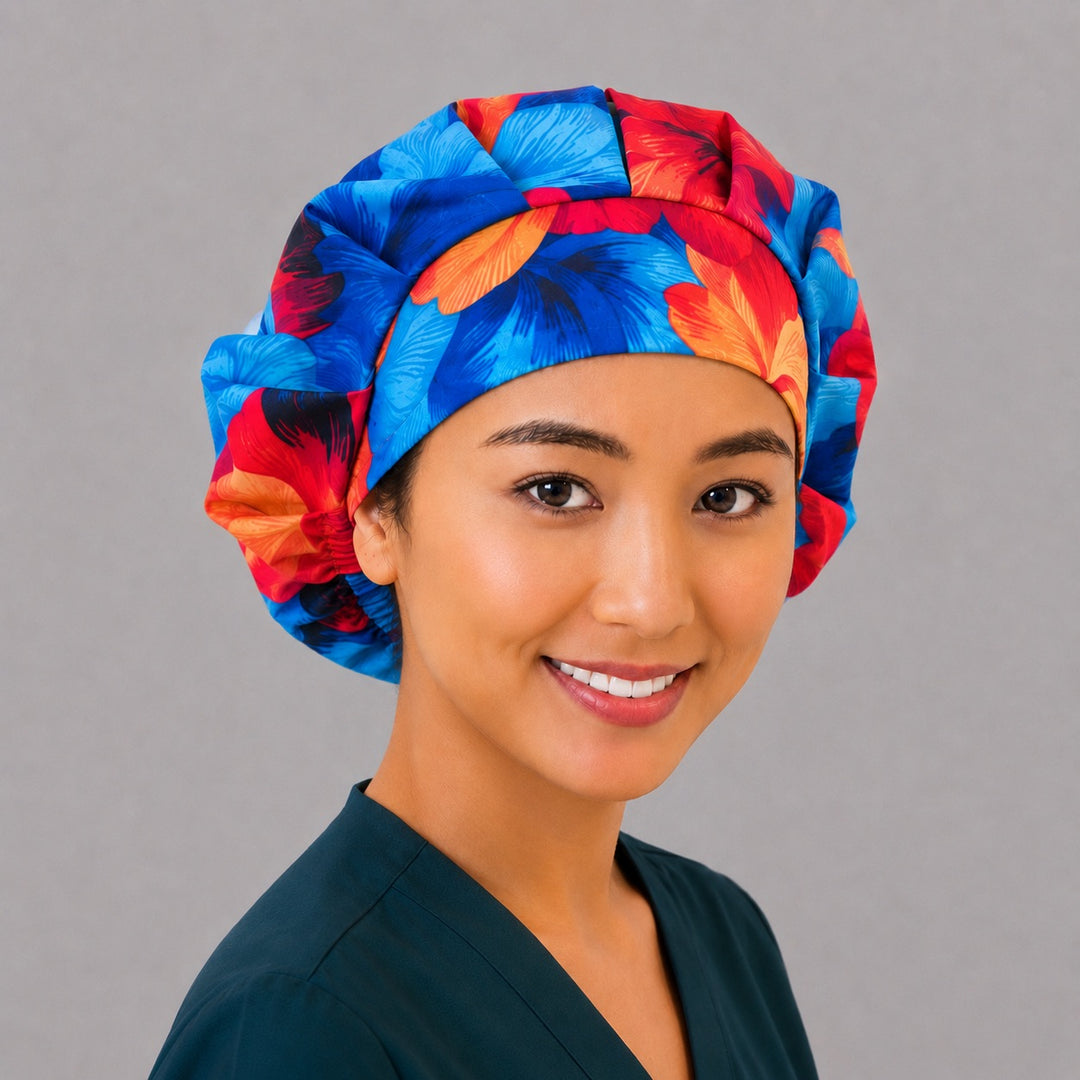 Blue and orange Hawaiian hibiscus bouffant scrub cap right three-quarter angle on smiling model showing blue and orange hibiscus flowers, women&