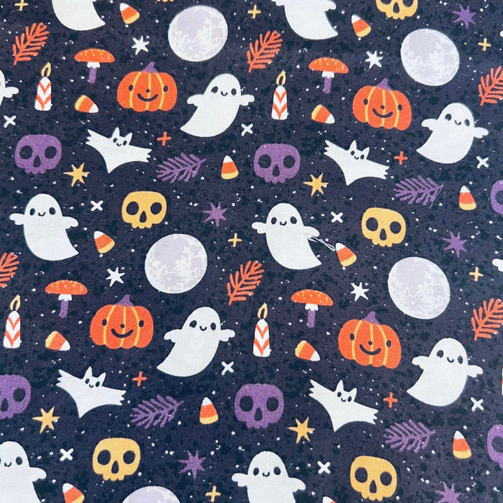 Fabric detail of the Boo-tiful Harvest scrub cap — close-up of ghosts, pumpkins, skulls and moons on navy cotton