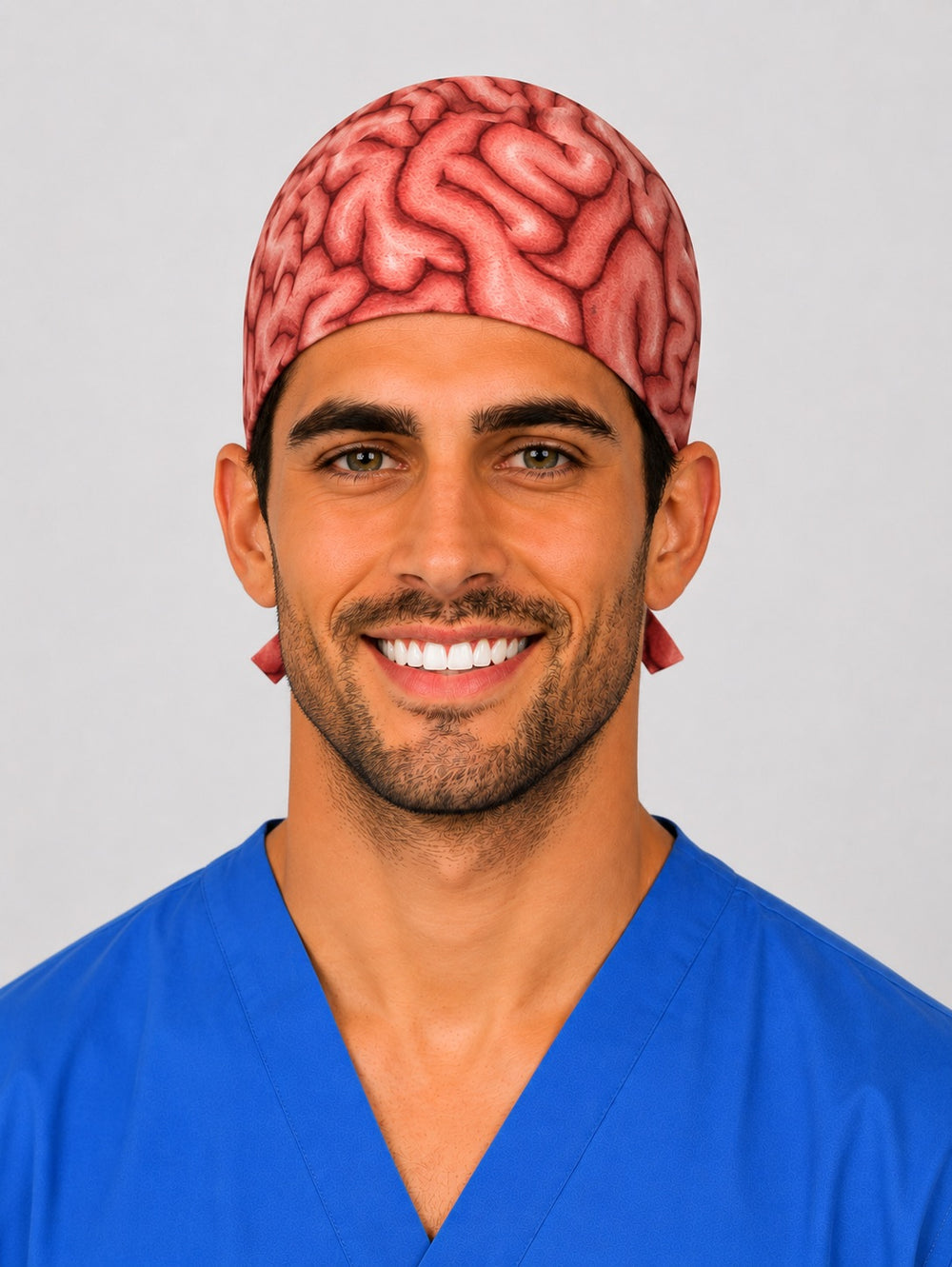 Man wearing a brain anatomy print tie-back scrub cap in coral and red, front view — handmade-in-USA men's neurosurgery surgical hat from OR World