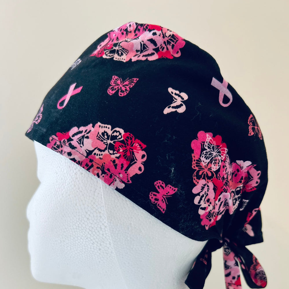 Left profile of breast cancer awareness butterfly scrub cap in black and pink, adjustable surgical hat