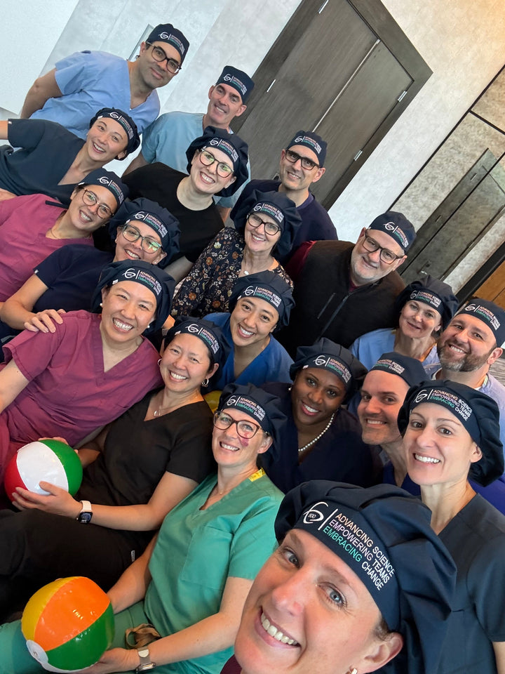 Large Society of Gynecologic Oncology (SGO) team in matching navy custom logo scrub caps — bulk logo surgical hat quote order for hospitals and universities, OR World