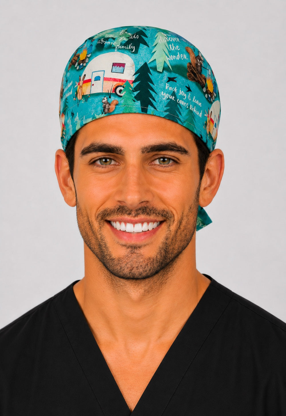 Summer camping scrub cap with vintage campers, pines and campfires on teal, handmade men's tie-back woodland surgical hat on male OR nurse, front view