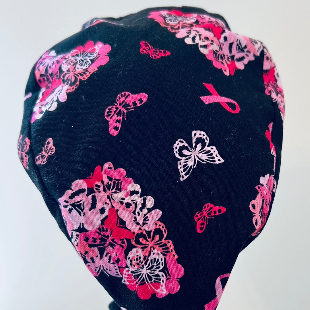 Top view of cancer awareness butterfly scrub cap with pink ribbons on black cotton