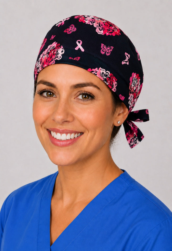 Cancer hearts scrub cap with pink butterfly hearts and awareness ribbons on black, handmade tie-back surgical hat for short hair on OR nurse, front view