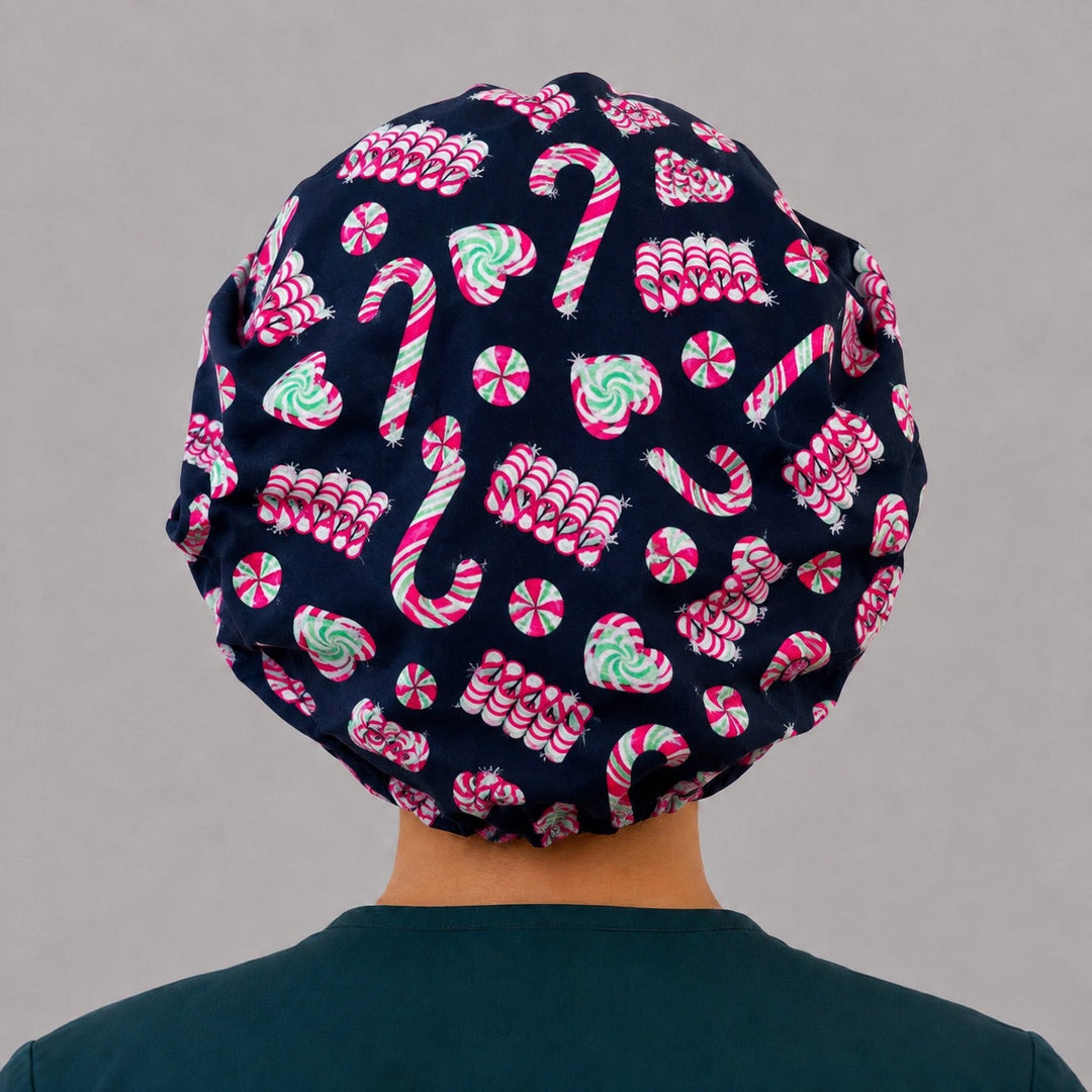 Back view of the candy cane bouffant scrub cap — full gathered fit showing candy canes, peppermint swirls and candy hearts on black