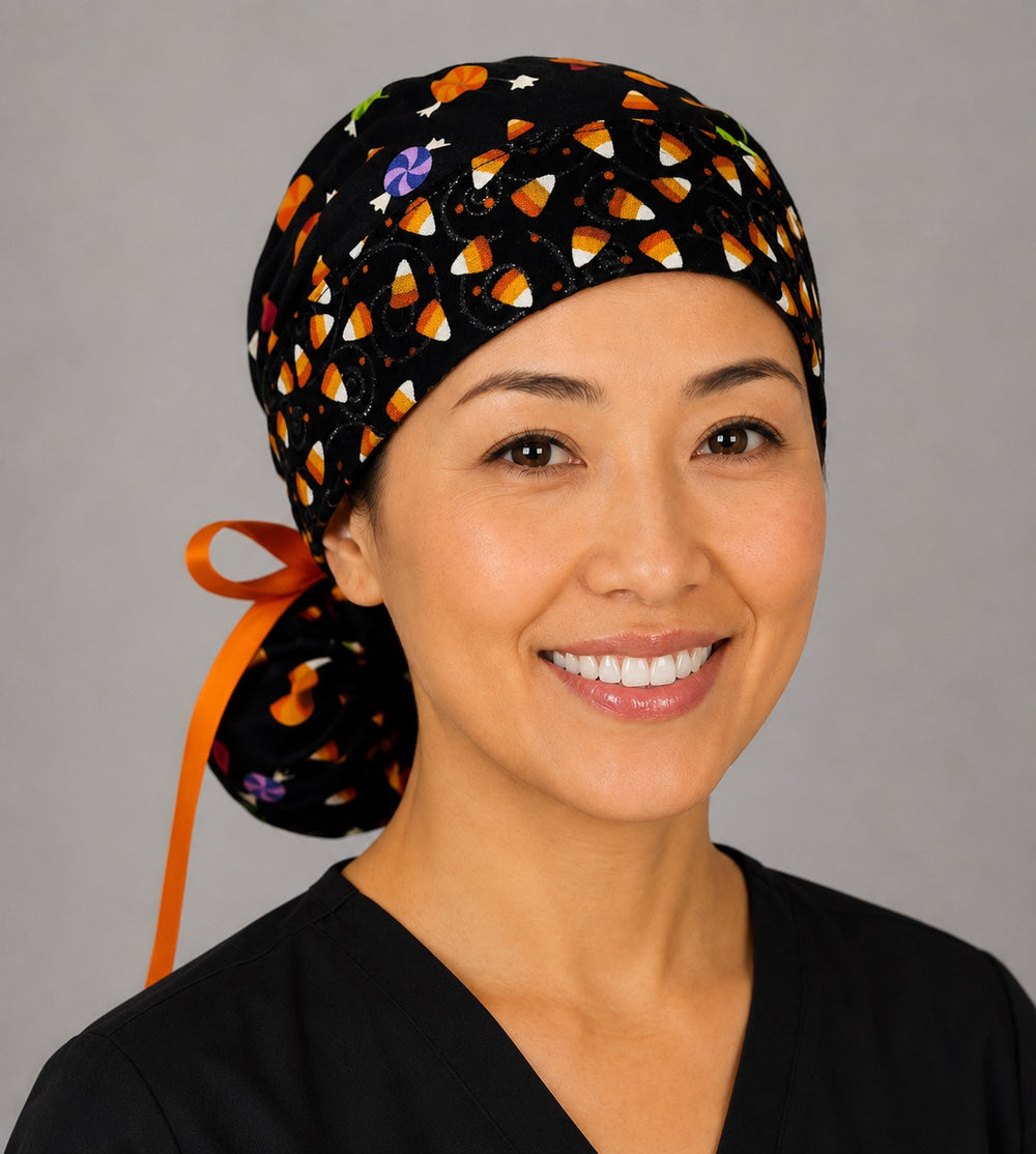 Halloween candy corn ponytail nurse cap right three-quarter angle on smiling model showing candy corn band with glitter swirls and orange ribbon bow