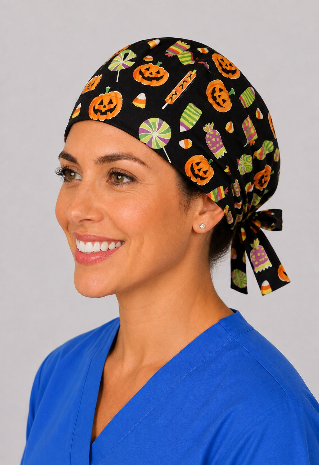 Left profile of candy corn and lollipop scrub cap for women with short hair, pediatric Halloween OR cap
