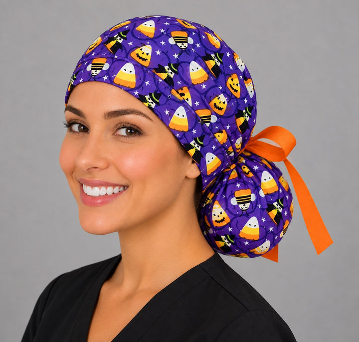 Candy corn ponytail surgical hat, left side smiling view — ponytail pouch with orange bow tie for long hair