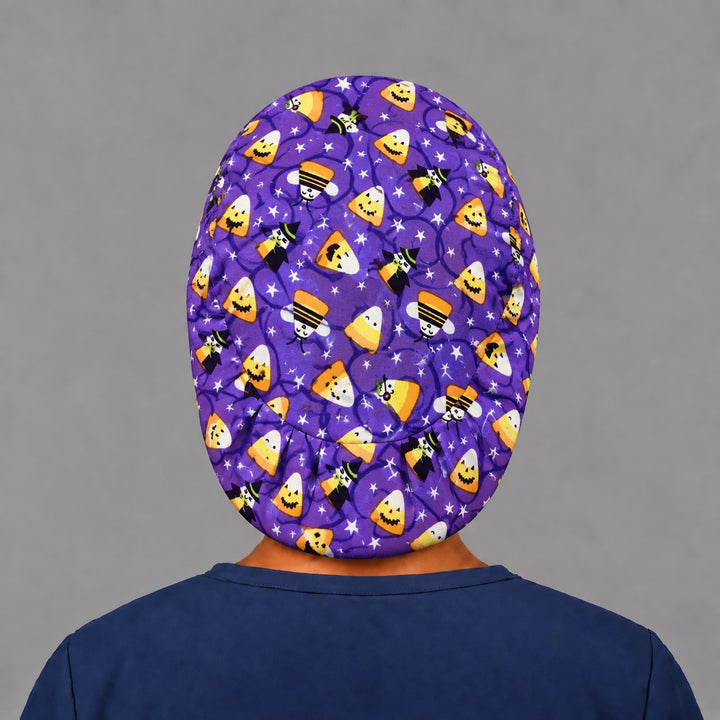 Back view of the candy corn witches Euro scrub cap — elastic gathered back showing candy corn and stars across the purple crown