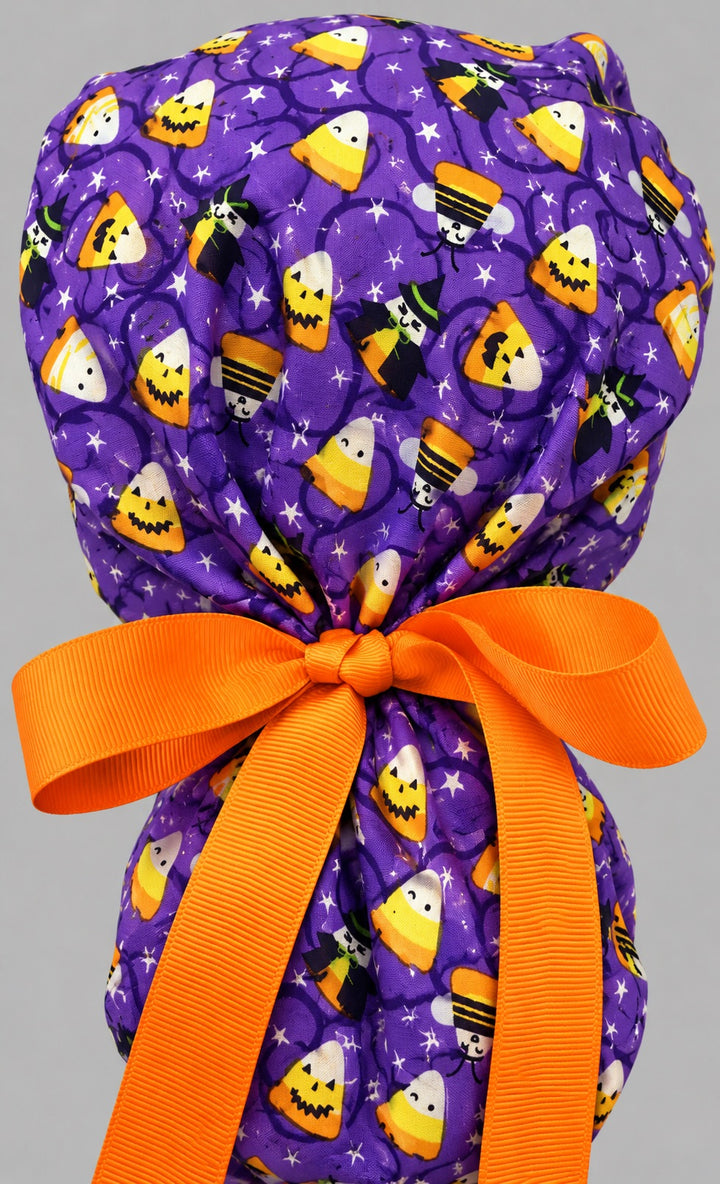 Back view of the candy corn witches ponytail scrub cap — gathered pouch tied with an orange grosgrain bow