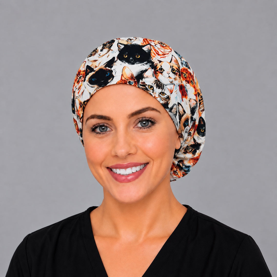 Woman wearing a Cat Face Euro scrub cap, front smiling view — watercolor cat portraits, adjustable surgical hat for vet techs