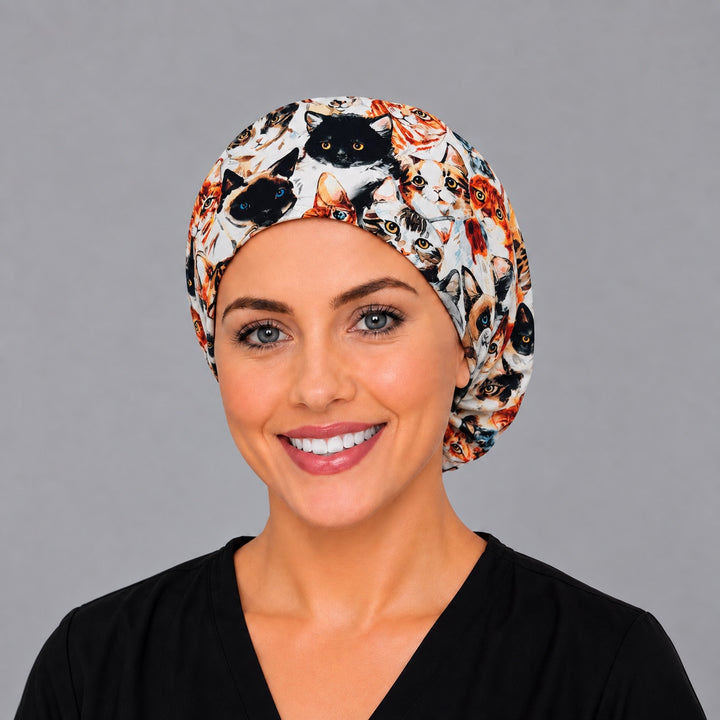 Woman wearing a Cat Face Euro scrub cap, front smiling view — watercolor cat portraits, adjustable surgical hat for vet techs