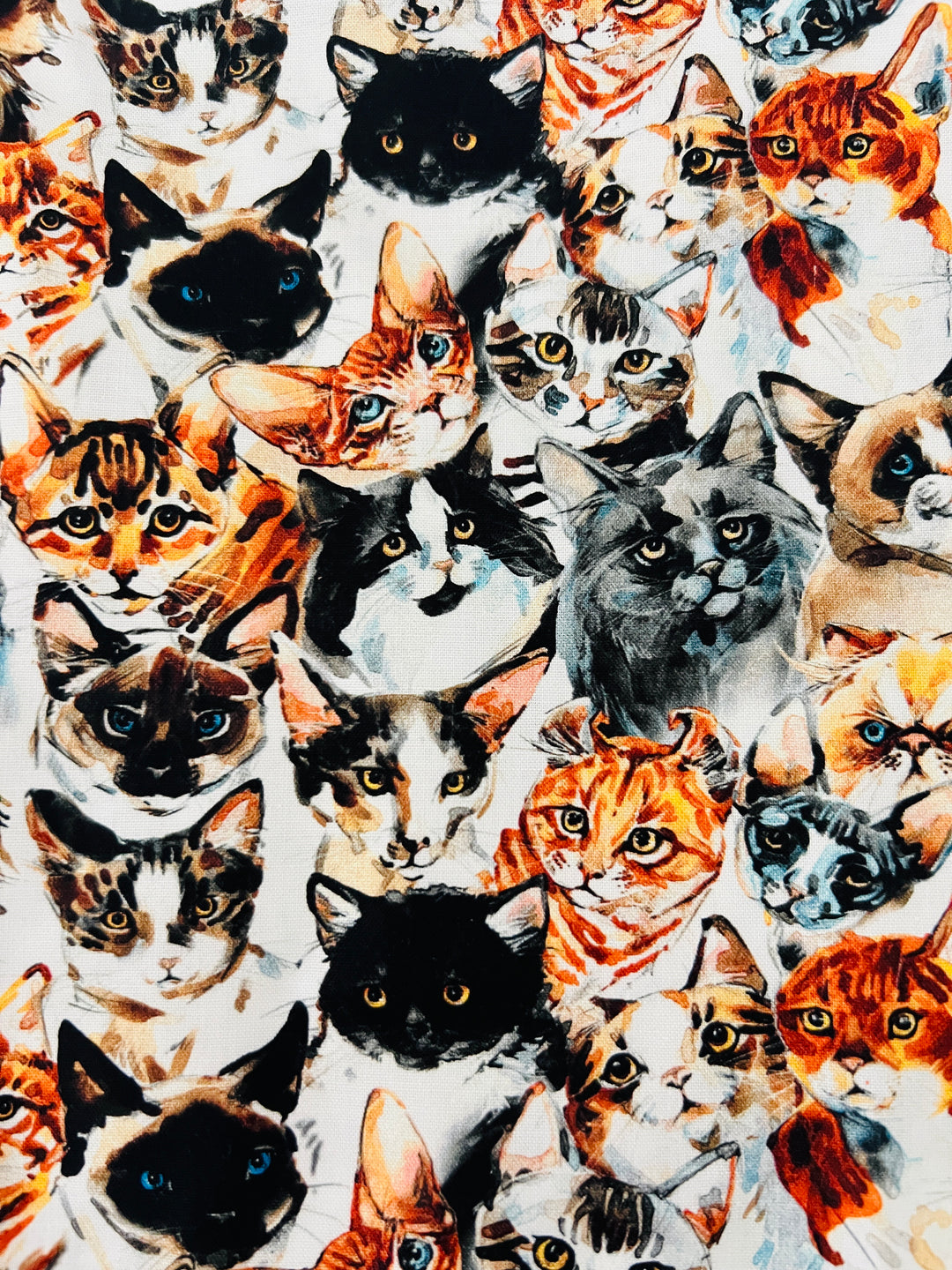 Fabric detail of the Cat Face scrub cap — close-up of watercolor cat portraits on white cotton