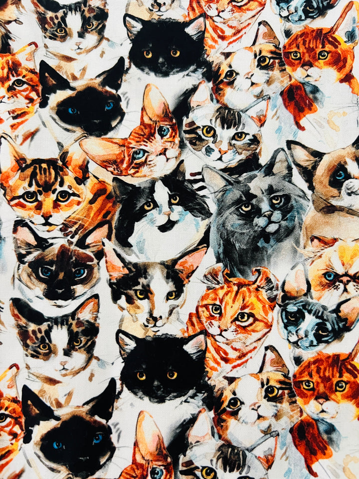 Fabric detail of the Cat Face scrub cap — close-up of watercolor cat portraits on white cotton