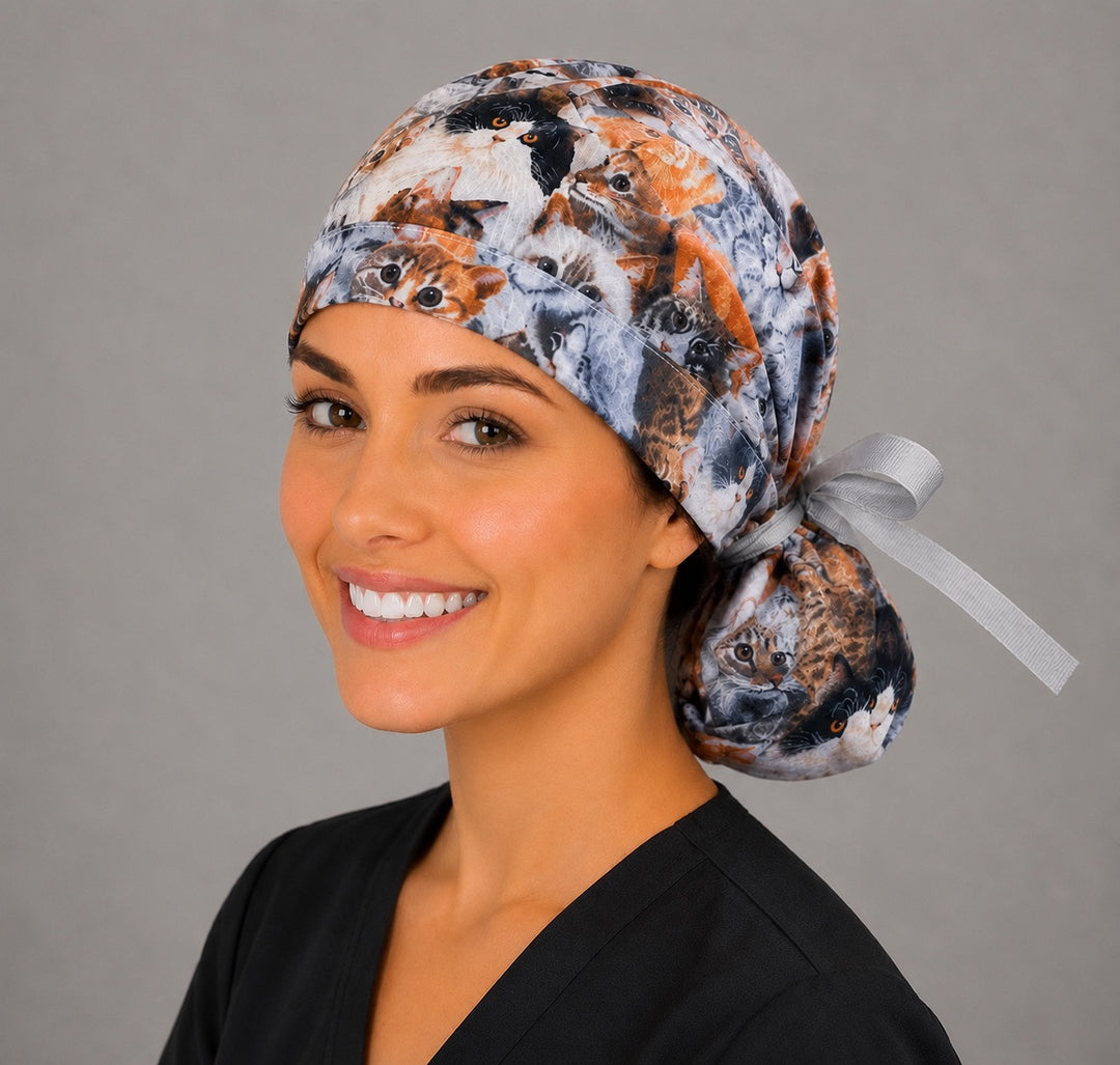 Cats and kittens ponytail scrub cap right three-quarter angle on smiling model showing photorealistic cats print and gray ribbon bow
