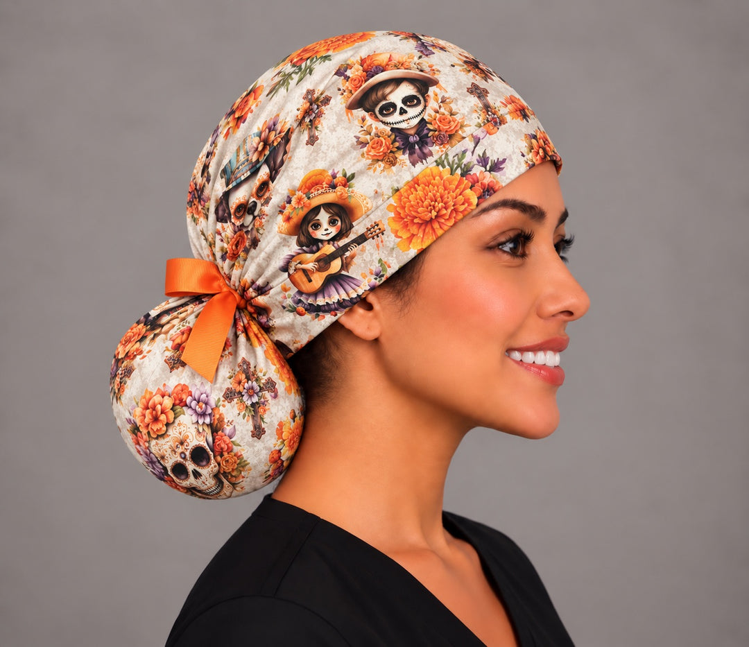 Right profile of the cempásuchil ponytail scrub cap on a surgical tech, low bun tucked into the pouch with an orange bow, handmade in the USA