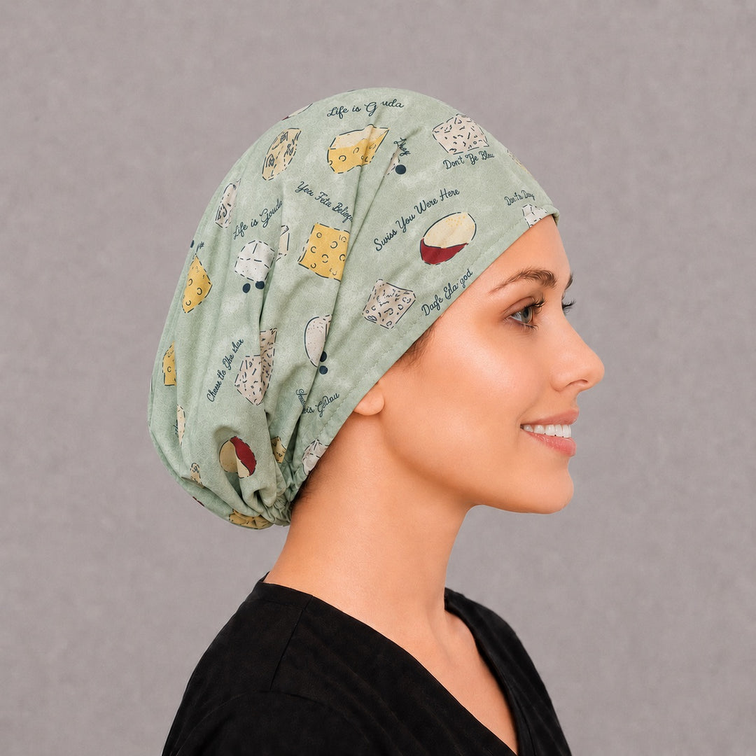 Back view of the cheese Euro scrub cap — full gathered coverage showing cheese wedges and puns across the sage crown