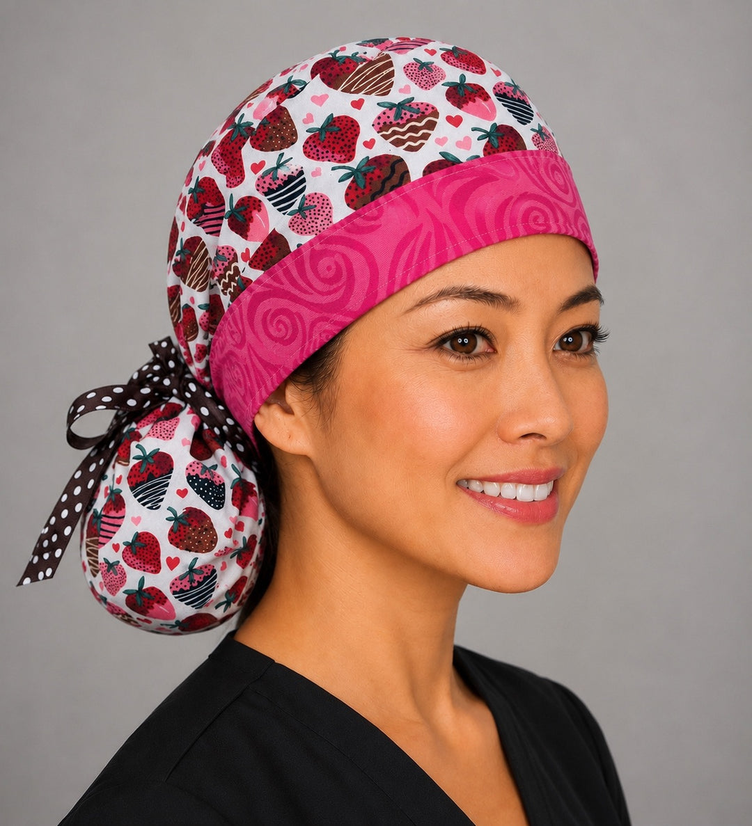 Chocolate-covered strawberry ponytail scrub cap right side profile with full ponytail pouch of chocolate-dipped strawberries and hearts and long brown polka-dot ribbon ties