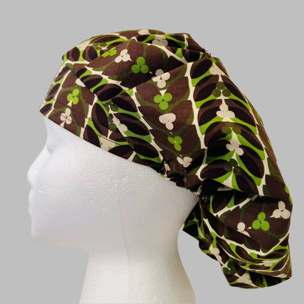 Side view of retro brown & green leaf bouffant scrub cap — handmade USA surgical hat for OR nurses with room for long hair.