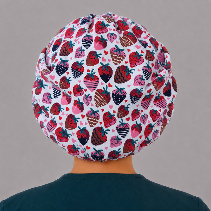 Back view of the chocolate strawberry bouffant scrub cap — full roomy fit showing chocolate-dipped berries and hearts on white