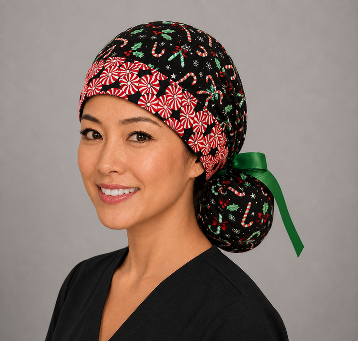 Christmas candy cane peppermint ponytail surgical cap left three-quarter angle on smiling model showing candy canes, holly and peppermint swirl band with green ribbon bow
