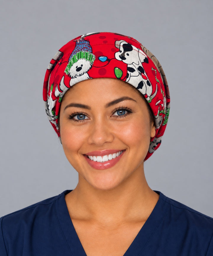 Woman wearing a Christmas dog Euro scrub cap, front view — Santa hat puppies and string lights on red, adjustable holiday surgical hat