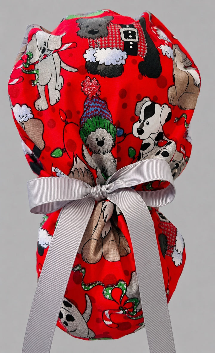 Christmas dogs ponytail scrub cap back view close-up showing gathered pouch full of pups in Santa hats, sweaters and candy canes on red with white grosgrain ribbon bow