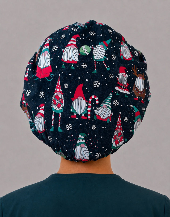 Woman wearing a Christmas gnome bouffant scrub cap, front view — navy gnome print with red, green and white snowflake band, adjustable women&