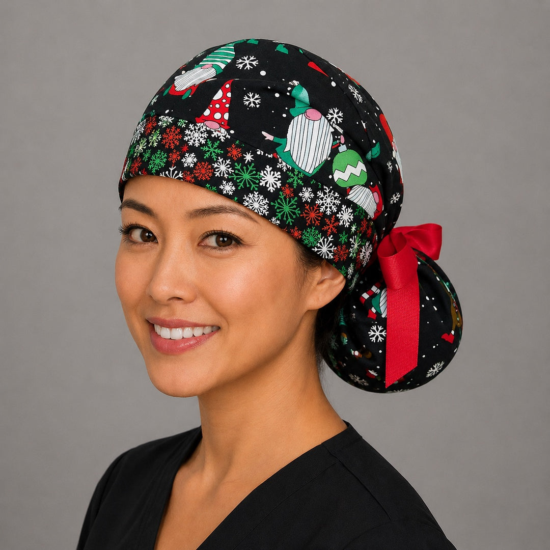 Woman wearing Christmas gnomes ponytail scrub cap, front view smiling with holiday gnomes and snowflakes on black with red green white snowflake band and red ribbon tie