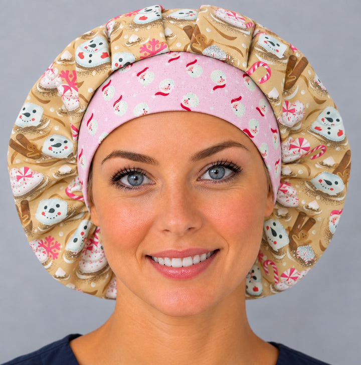 Woman wearing a Christmas marshmallow bouffant scrub cap, front view — pink Santa snowman band with gold cocoa print, full coverage surgical hat