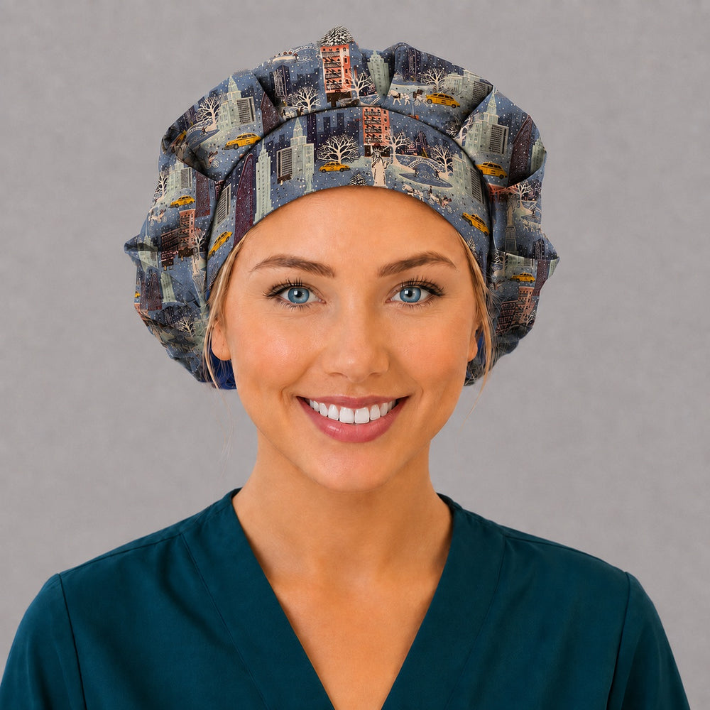 Woman wearing a Christmas in the City bouffant scrub cap, front view — snowy New York skyline with taxis and Christmas trees on twilight blue, adjustable women's surgical hat