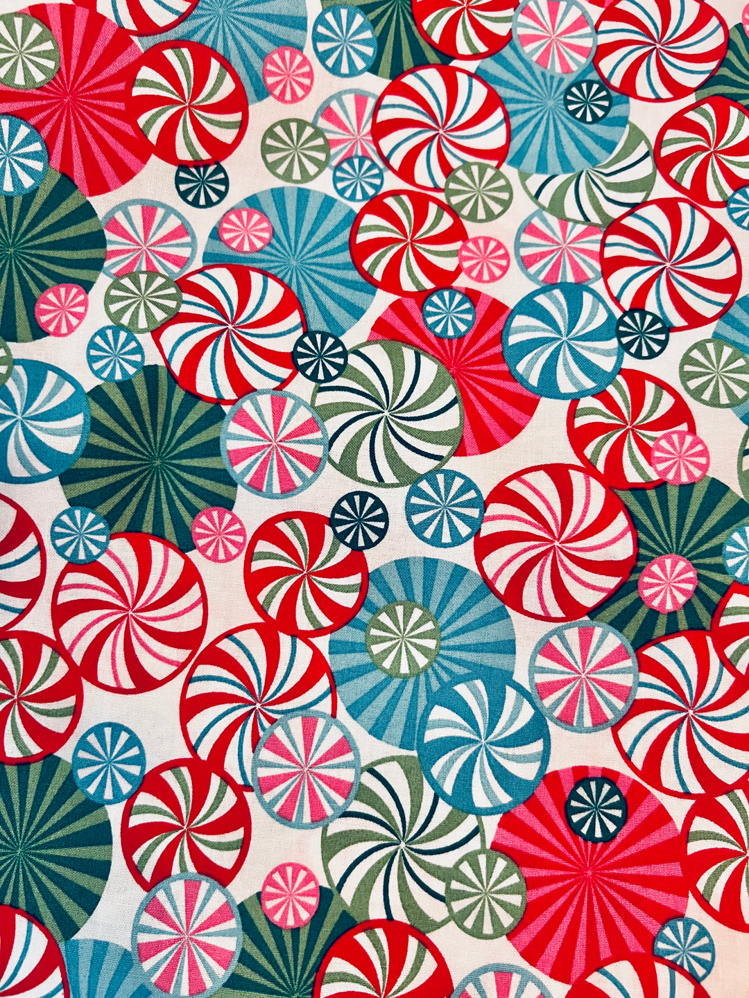 Fabric detail of the Christmas peppermint bouffant — close-up of candy swirls in red, teal, pink and sage on white cotton