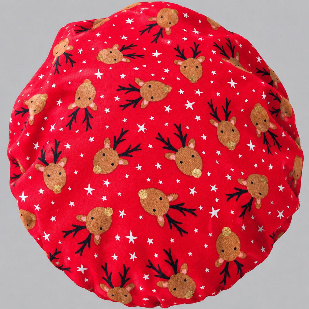 Flat-lay of the Christmas reindeer bouffant scrub cap — red fabric detail showing reindeer with black antlers, gold noses and white stars