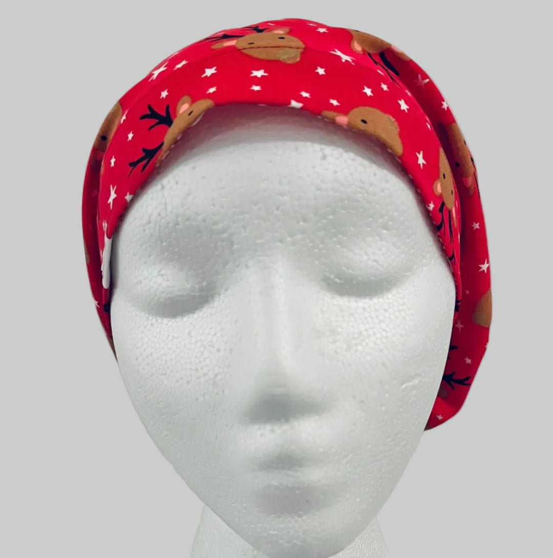 Christmas reindeer euro scrub cap with adorable brown reindeer faces on a festive red background with white stars, handmade unisex surgical cap for nurses, surgeons, dental professionals, veterinarians, medical staff, holiday scrub hat gift, front view