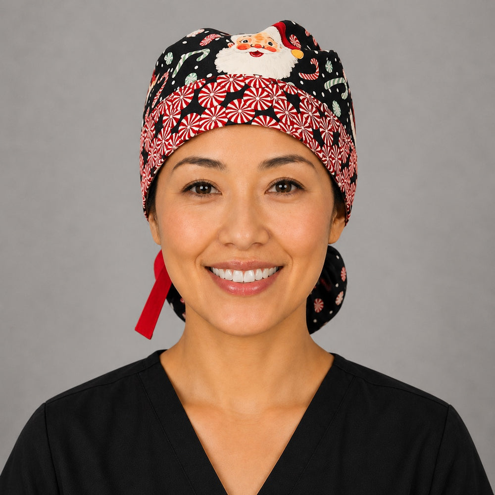 Christmas Santa ponytail scrub cap front band close-up on smiling model showing red-and-white peppermint band with vintage Santa faces on navy and red ribbon