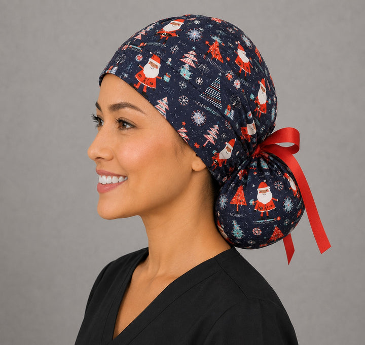 Woman wearing Christmas Santa ponytail scrub cap, front view smiling with cheerful Santas, Christmas trees and snowflakes on navy blue with red ribbon tie