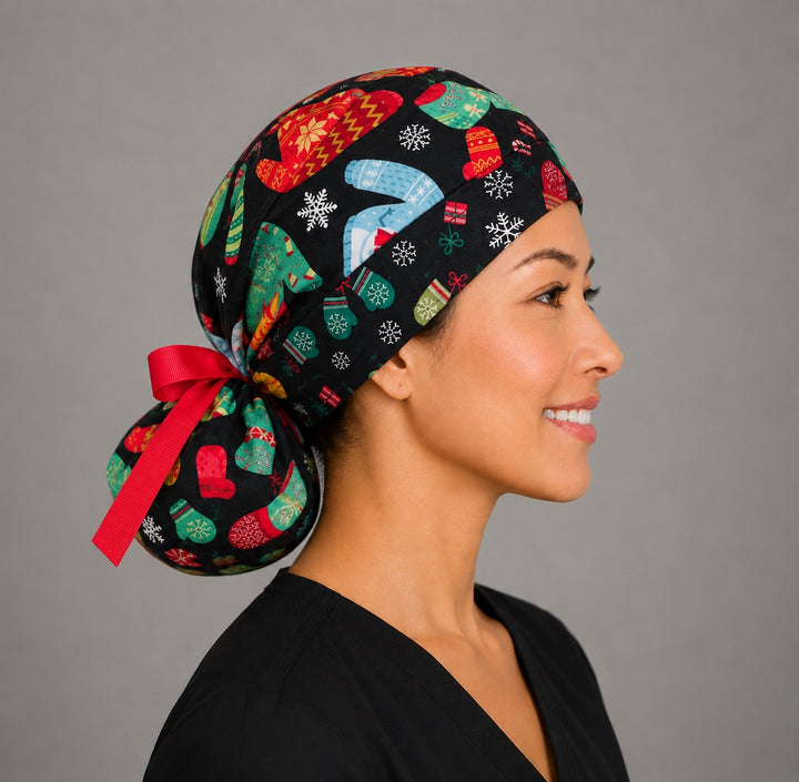 Christmas ugly sweater ponytail scrub cap left side profile showing gathered pouch of knit sweaters, mittens and snowflakes on black with red ribbon tie