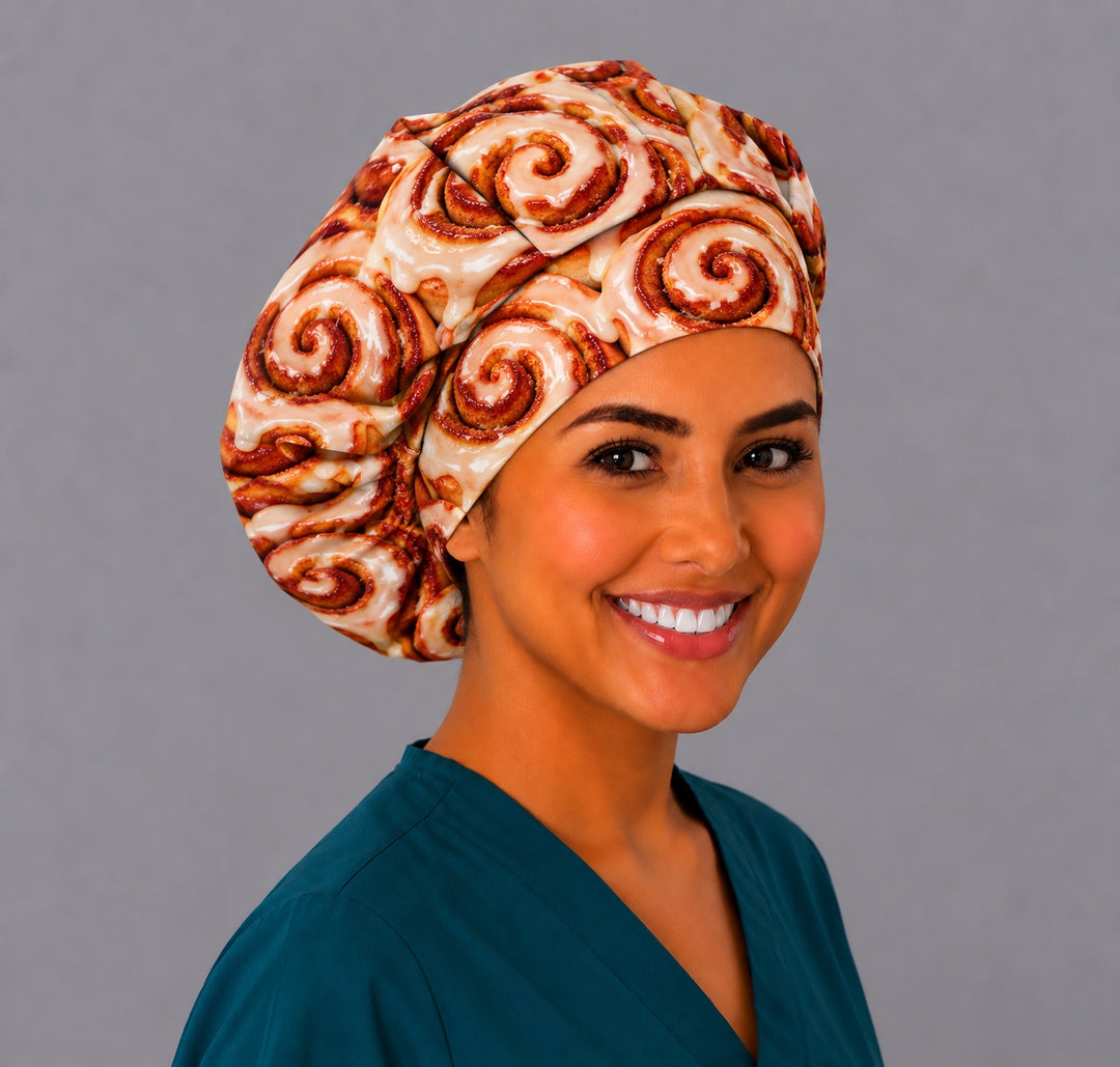 Nurse wearing a funny cinnamon roll bouffant scrub cap with glazed cinnamon buns, an OR World original food print surgical hat handmade in the USA