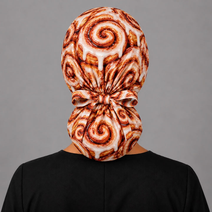 Back view of a cinnamon roll ponytail scrub cap showing the ponytail pouch and adjustable ribbon tie
