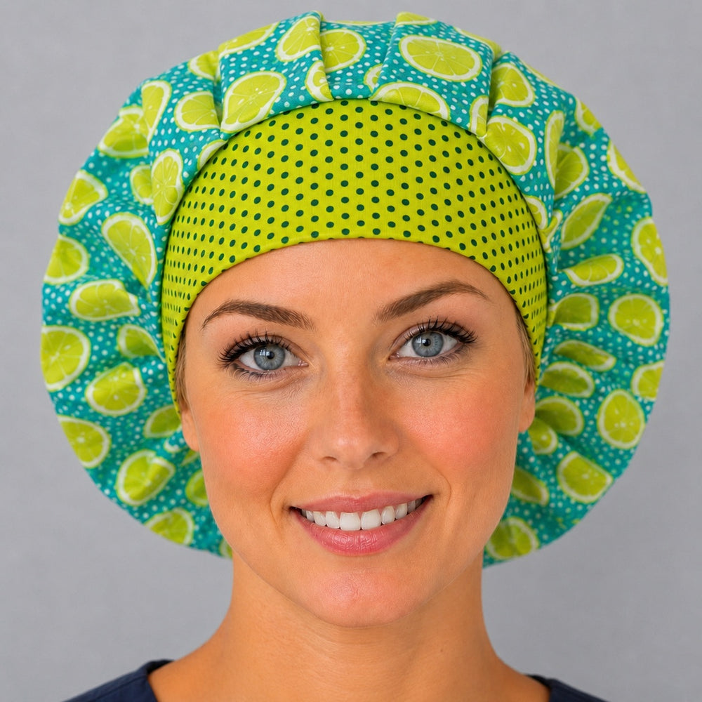 Woman wearing a bright citrus lemon lime bouffant scrub cap, front view — teal fruit print with lime polka-dot band, adjustable women's nurse hat