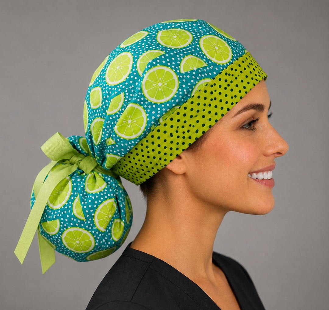 Citrus lemon lime ponytail scrub cap right side profile showing gathered pouch of lime slices on teal polka dot ground and long green ribbon ties