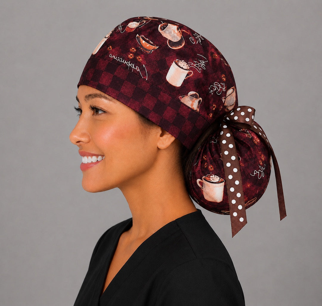 Brown coffee lover ponytail scrub cap left profile close-up showing cappuccino, latte and coffee bean print on brown checkerboard with polka dot ribbon tie