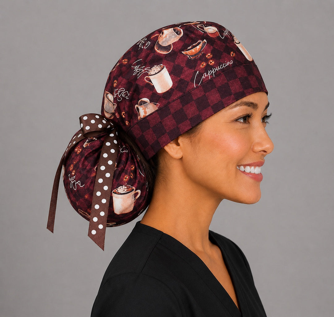 Brown coffee lover ponytail surgical cap left side view showing gathered ponytail pouch of cappuccinos, lattes and coffee beans with brown polka dot ribbon bow