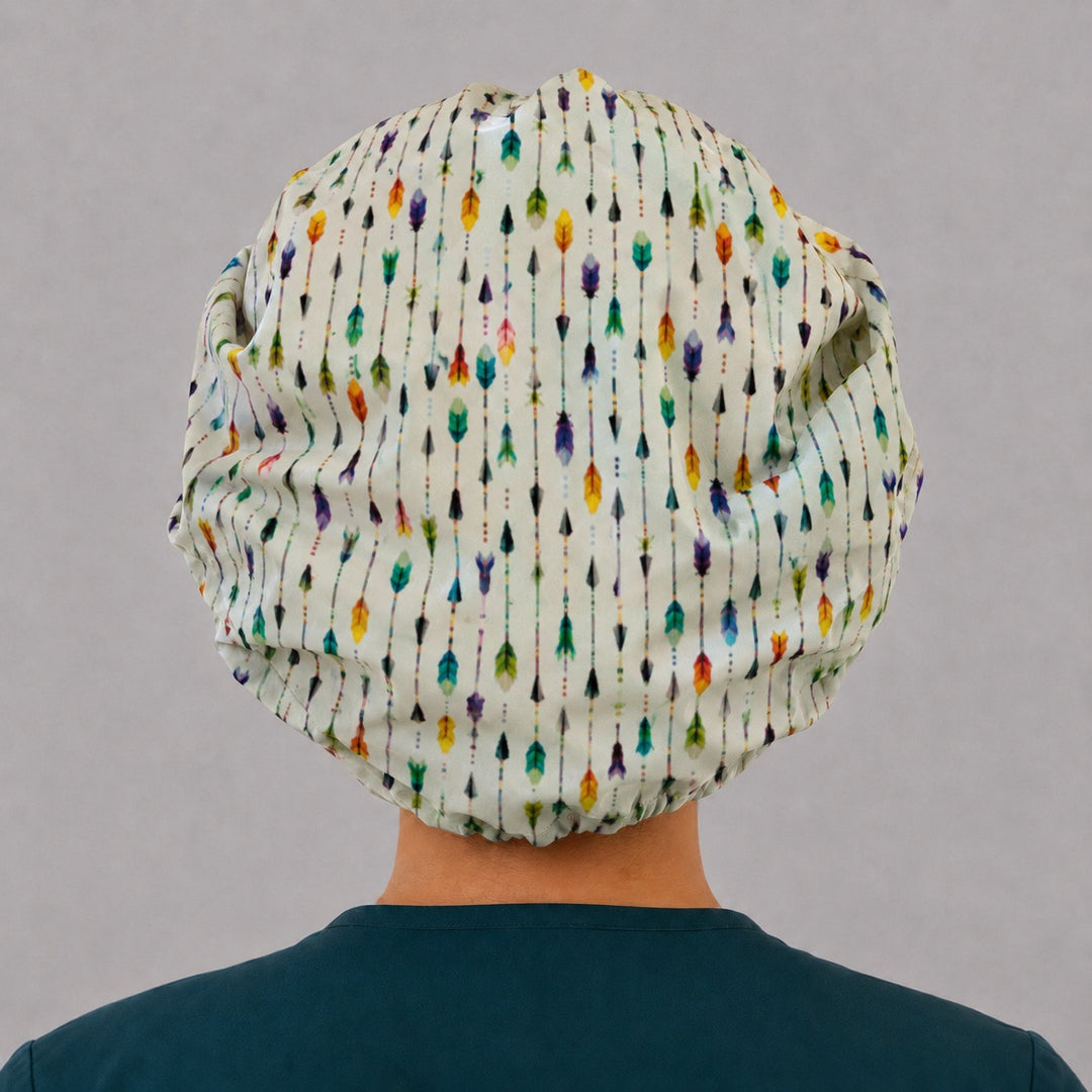 Back view of the colorful arrows bouffant scrub cap — full gathered fit showing watercolor arrows and feathers across the white crown