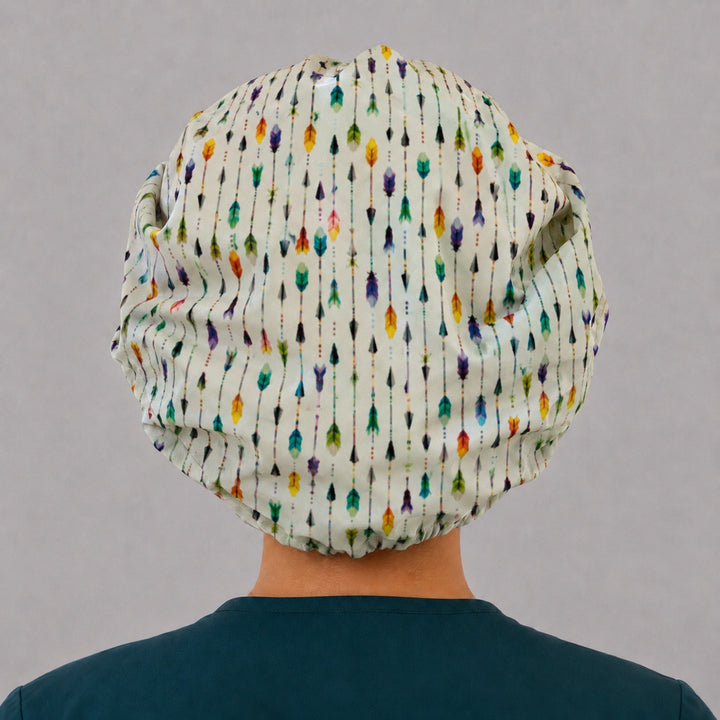 Back view of the colorful arrows bouffant scrub cap — full gathered fit showing watercolor arrows and feathers across the white crown