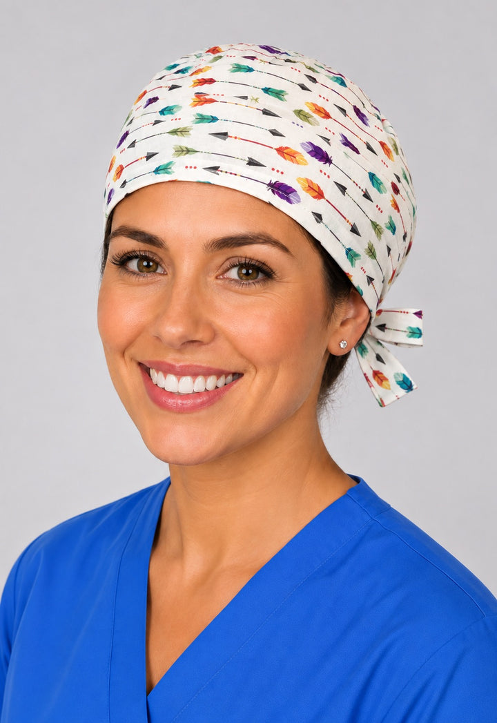 Nurse wearing colorful arrow and feather tie back scrub cap, white boho surgical hat with side tie by OR World