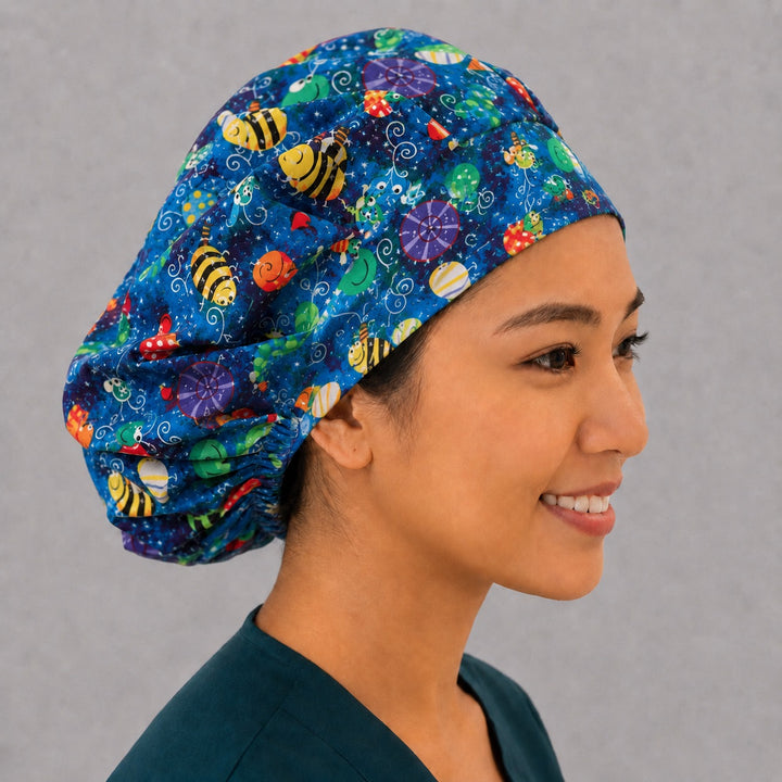 Side view of the colorful bug and butterfly bouffant surgical hat — bees, snails and dragonflies on starry blue, roomy cotton cap for nurses