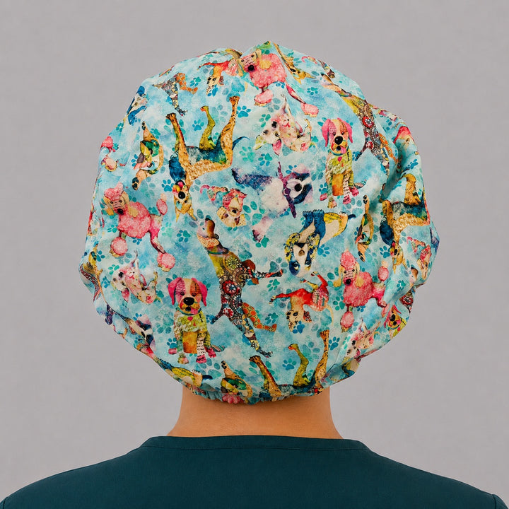 Back view of the colorful dog bouffant scrub cap — full roomy fit covered in watercolor dogs and paw prints, adjustable elastic surgical cap