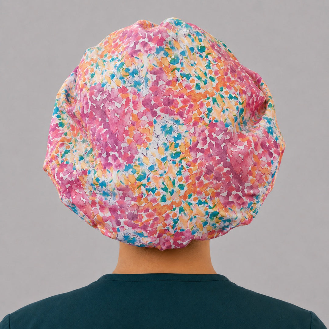 Colorful floral watercolor bouffant scrub cap back view showing full print of bright pink teal and orange watercolor florals, OR World surgical hat
