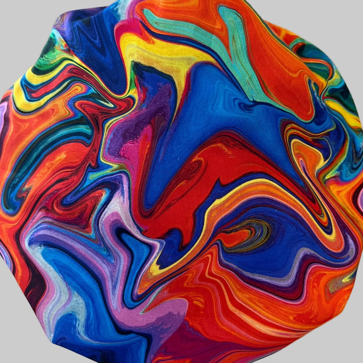 Side view of rainbow ripple bouffant scrub cap — handmade USA colorful surgical hat for OR nurses with room for long hair.